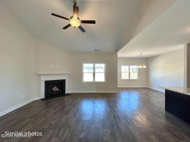 unfurnished living room with dark hardwood / wood-style floors and ceiling fan with notable chandelier