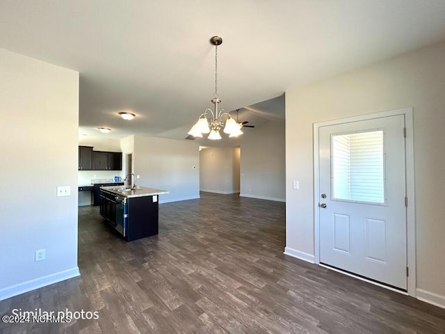 kitchen with a kitchen island with sink, sink, a notable chandelier, dark hardwood / wood-style floors, and hanging light fixtures