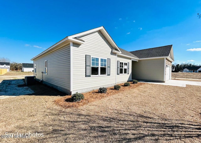 view of front of home featuring cooling unit and a garage