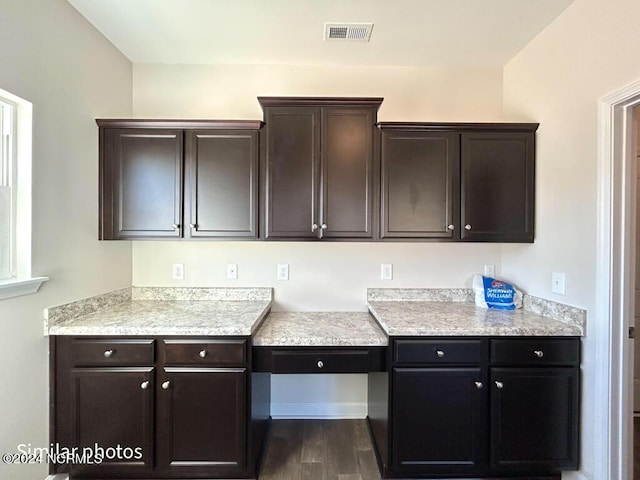 kitchen featuring dark hardwood / wood-style flooring and dark brown cabinetry