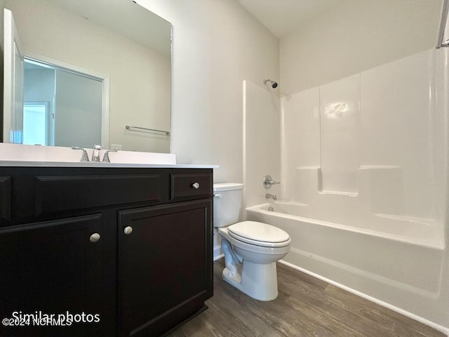 full bathroom with hardwood / wood-style floors, vanity, toilet, and shower / washtub combination