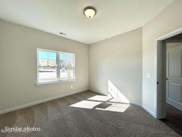 empty room with dark colored carpet