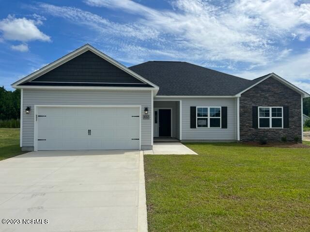 view of front of property with a garage and a front lawn