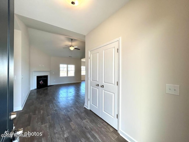 unfurnished living room with ceiling fan, dark wood-type flooring, and lofted ceiling