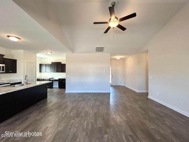 kitchen featuring ceiling fan, light stone countertops, sink, dark hardwood / wood-style flooring, and lofted ceiling