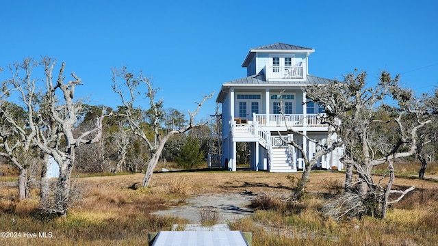 view of front of property with ceiling fan, a balcony, and a porch