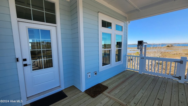 wooden terrace featuring a water view and covered porch