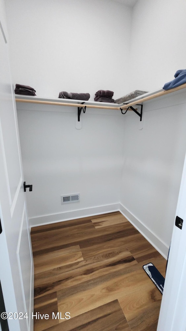 walk in closet with hardwood / wood-style flooring