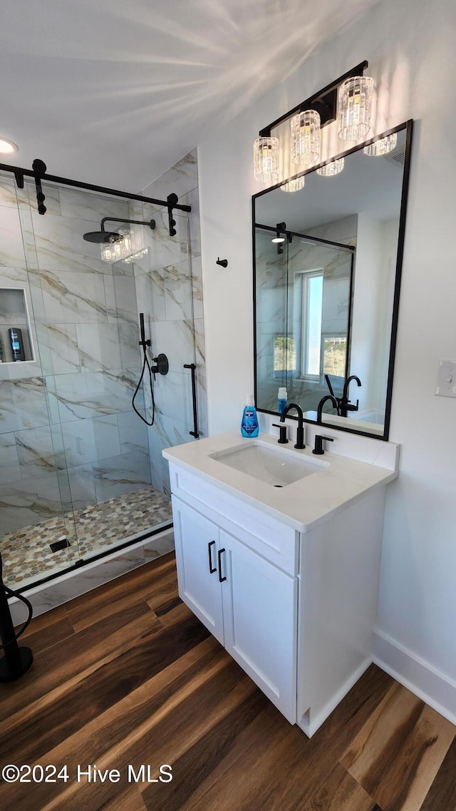 bathroom featuring walk in shower, vanity, and hardwood / wood-style flooring