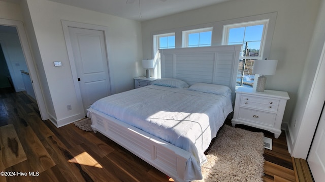 bedroom with dark wood-type flooring and a closet