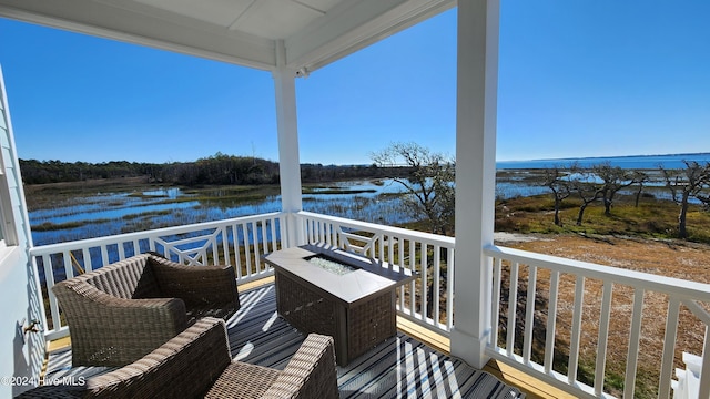 balcony featuring a water view and a fire pit