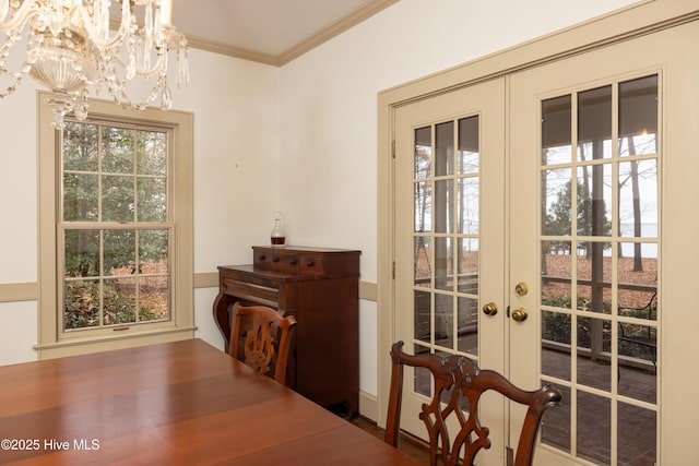 interior space with a chandelier, ornamental molding, and french doors