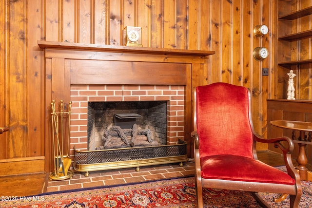 living area featuring a fireplace, built in features, and wood walls