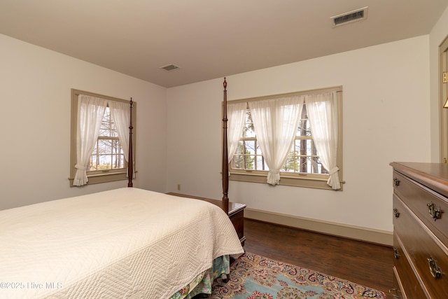 bedroom with dark hardwood / wood-style floors