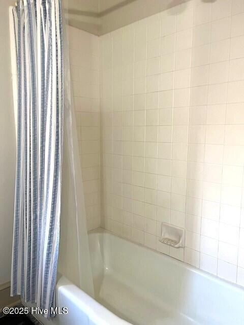 bathroom with shower / tub combo with curtain