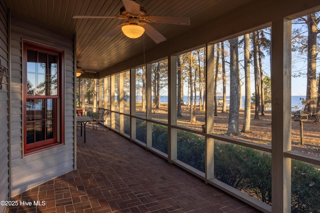 unfurnished sunroom with a water view, ceiling fan, and wood ceiling