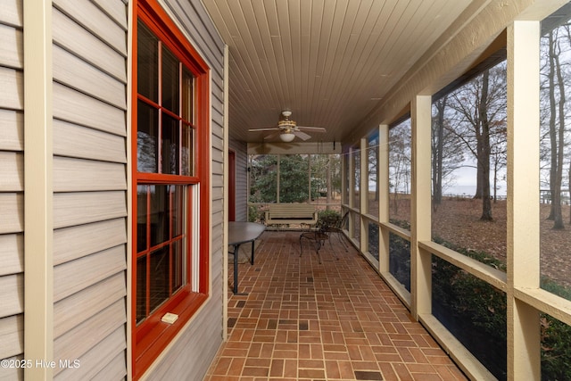 unfurnished sunroom featuring ceiling fan and wood ceiling