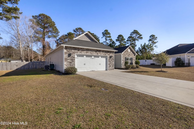 view of front facade with a garage, a front lawn, and central air condition unit