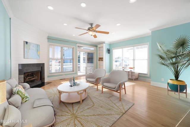 living room with crown molding, light hardwood / wood-style flooring, and ceiling fan