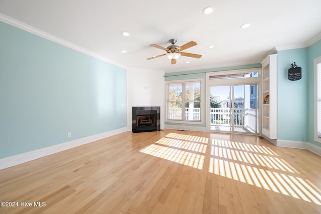 unfurnished living room featuring ceiling fan, ornamental molding, and light wood-type flooring