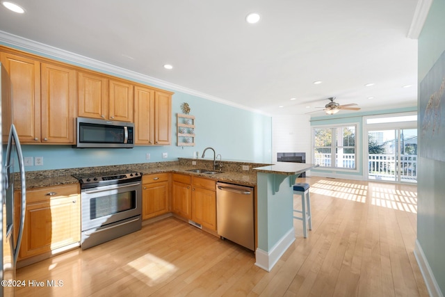 kitchen featuring appliances with stainless steel finishes, sink, a breakfast bar area, and kitchen peninsula