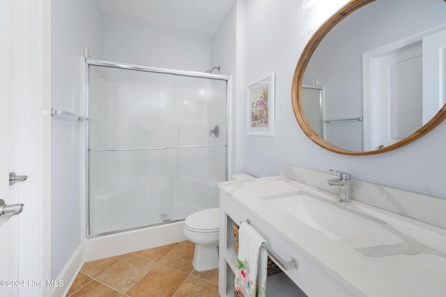 bathroom with an enclosed shower, vanity, tile patterned flooring, and toilet