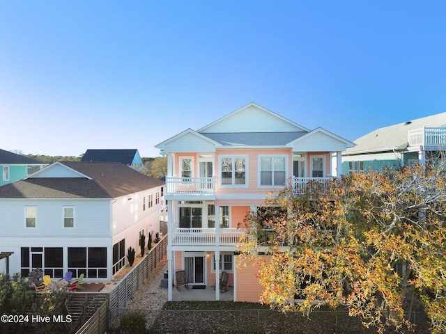 rear view of property featuring a patio area and a balcony