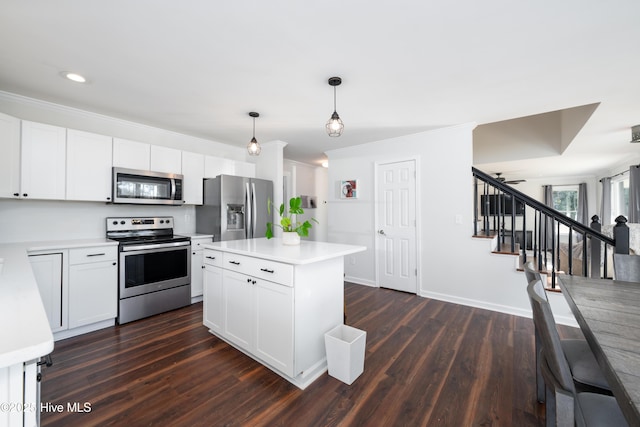 kitchen with pendant lighting, a kitchen island, white cabinets, and stainless steel appliances