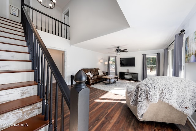 bedroom featuring ceiling fan with notable chandelier and dark hardwood / wood-style flooring