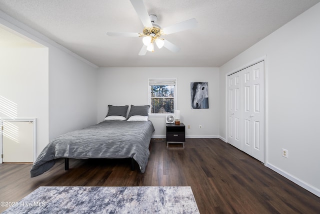 bedroom featuring ceiling fan, dark wood-type flooring, and a closet