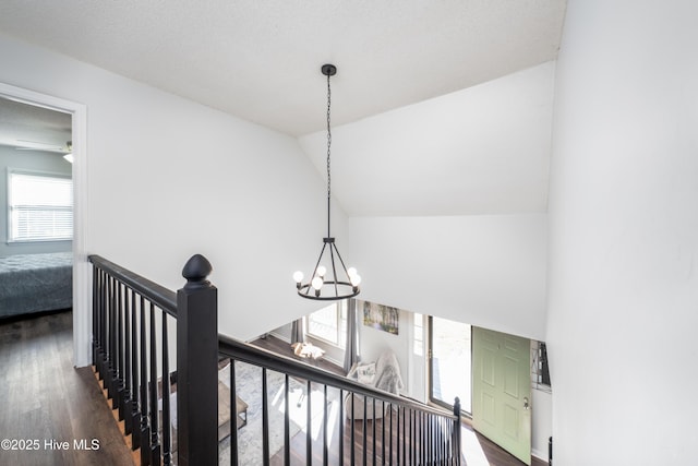 corridor featuring an inviting chandelier, dark hardwood / wood-style flooring, and vaulted ceiling