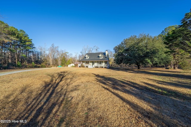 cape cod-style house with covered porch and a front yard