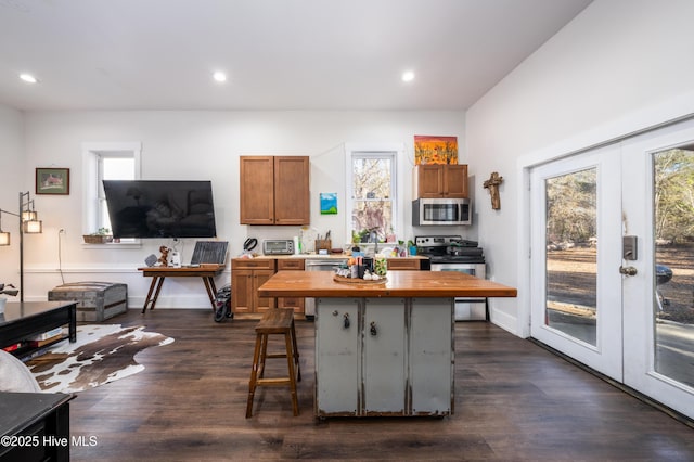 kitchen with a breakfast bar, appliances with stainless steel finishes, dark hardwood / wood-style floors, and french doors