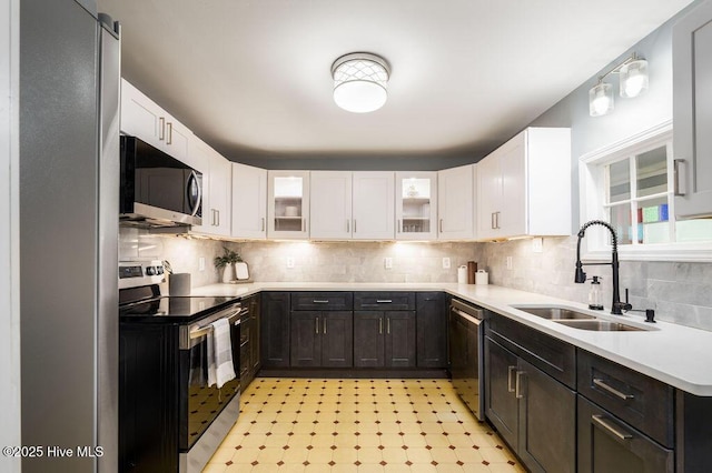 kitchen with decorative backsplash, sink, white cabinets, and stainless steel appliances