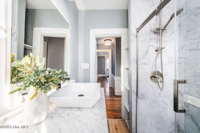 bathroom featuring a tile shower, vanity, and hardwood / wood-style flooring