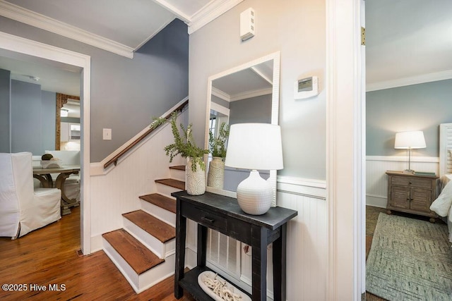 stairway with hardwood / wood-style floors and crown molding