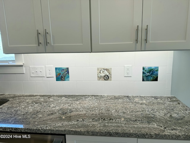 interior details featuring backsplash, dark stone counters, and gray cabinetry