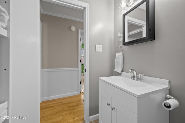 bathroom featuring crown molding, vanity, and wood-type flooring