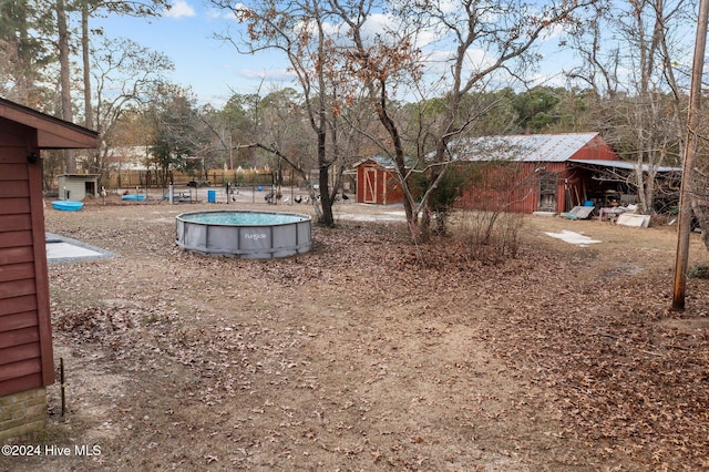 view of yard featuring a fenced in pool and a shed