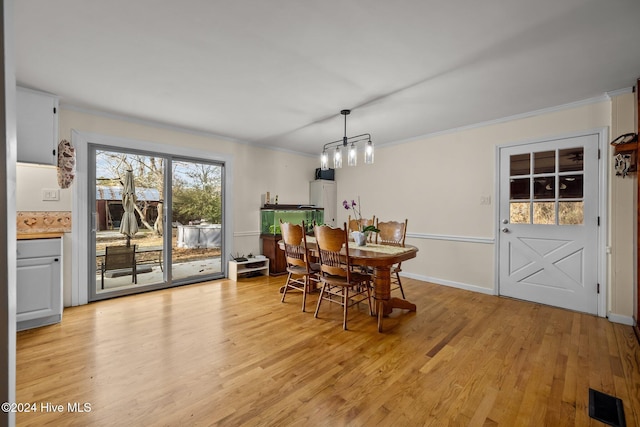 dining area with light hardwood / wood-style flooring and ornamental molding