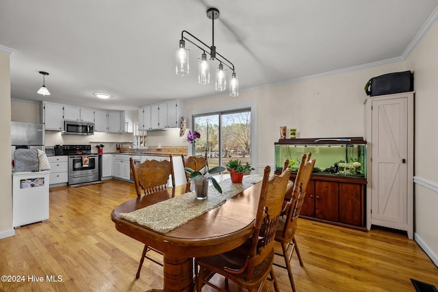 dining space featuring crown molding and light hardwood / wood-style floors