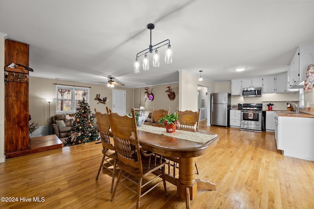 dining area featuring light hardwood / wood-style floors, ceiling fan, and sink