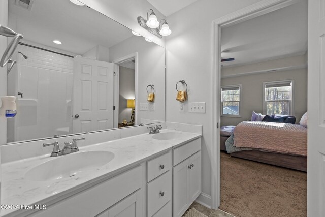 bathroom with vanity, ceiling fan, and walk in shower