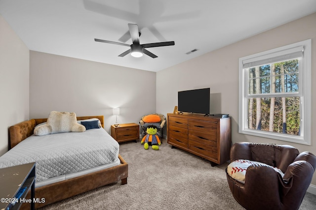 carpeted bedroom with multiple windows and ceiling fan