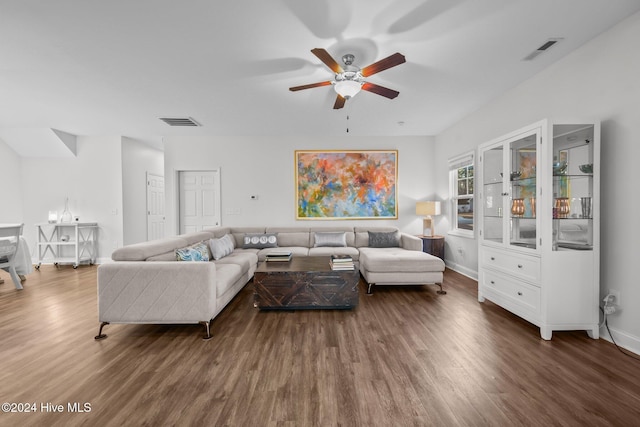 living room featuring ceiling fan and dark wood-type flooring