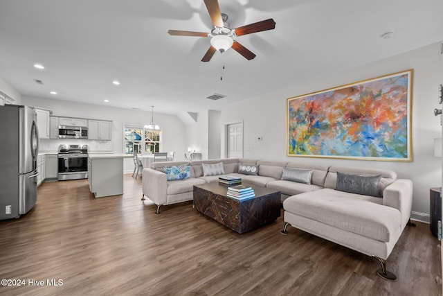 living room with ceiling fan with notable chandelier and dark hardwood / wood-style flooring