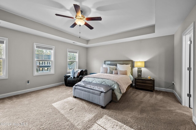 bedroom featuring carpet flooring, ceiling fan, and a tray ceiling