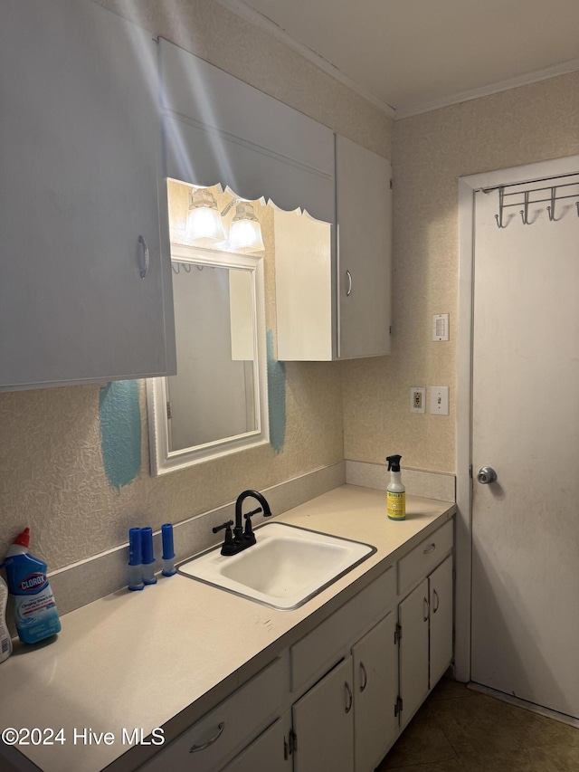 kitchen with white cabinets, backsplash, crown molding, and sink