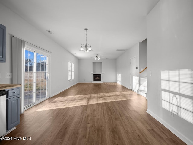 unfurnished living room featuring wood-type flooring and ceiling fan with notable chandelier