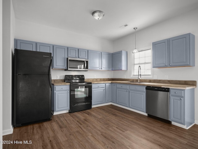 kitchen featuring dark hardwood / wood-style flooring, gray cabinetry, sink, black appliances, and hanging light fixtures